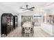 Elegant dining room with a ceiling fan, large windows, and stylish china cabinets at 15814 W Adams St, Goodyear, AZ 85338