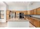 Well-lit kitchen featuring stainless steel appliances, wood cabinetry, and tile flooring at 15814 W Adams St, Goodyear, AZ 85338