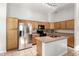 Well-lit kitchen featuring a stainless-steel refrigerator, ample cabinet space, and a functional kitchen island at 15814 W Adams St, Goodyear, AZ 85338