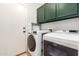 Clean laundry area with cabinets and modern washer and dryer units at 15814 W Adams St, Goodyear, AZ 85338
