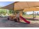 Playground featuring a vibrant fire engine play structure with slide and swings under a shade ramada for fun and safety at 16333 N 181St Ave, Surprise, AZ 85388
