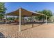 A shaded playground with swings, slide and climbing structure provides a fun space for outdoor play at 16333 N 181St Ave, Surprise, AZ 85388