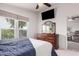 Bright main bedroom with a wooden dresser, a wall-mounted TV, and an open doorway to the living room at 2263 N Trekell Rd # 20, Casa Grande, AZ 85122
