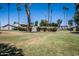 View of the community's well-kept green spaces, palm trees, and building exteriors on a sunny day at 2645 W Elm St, Phoenix, AZ 85017