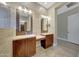 Bathroom featuring double sinks, wood cabinets, tile flooring, and entrance to large closet at 28770 N 69Th Ln, Peoria, AZ 85383