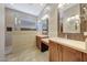 Bathroom featuring double sinks, wood cabinets, tiled walls, and a large shower with glass partition at 28770 N 69Th Ln, Peoria, AZ 85383