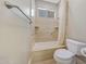 Bathroom featuring a shower-tub combo with travertine tile and a built-in niche at 28770 N 69Th Ln, Peoria, AZ 85383