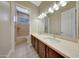 Bathroom with a double vanity, large mirror, and shower-tub combo with tile surround at 28770 N 69Th Ln, Peoria, AZ 85383