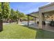 Lush backyard with a covered patio, sparkling pool, and well-manicured lawn at 6264 E Omega St, Mesa, AZ 85215