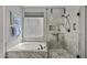 Bright bathroom featuring a soaking tub and a glass-enclosed shower with stylish tile and modern fixtures at 6264 E Omega St, Mesa, AZ 85215