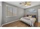 Bedroom with a ceiling fan, wood-look floors, and plantation shutters on the windows at 6264 E Omega St, Mesa, AZ 85215