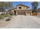 Charming two-story home featuring a three-car garage and desert landscaping at 6264 E Omega St, Mesa, AZ 85215