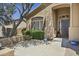 Charming home entrance with stone detailing, mature trees, and a decorative front door at 6264 E Omega St, Mesa, AZ 85215