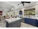 Open kitchen concept with gray island, blue cabinets, and view to the backyard pool and dining area at 6264 E Omega St, Mesa, AZ 85215