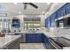 Modern kitchen features ample blue cabinetry, stainless steel appliances, and a window to the backyard at 6264 E Omega St, Mesa, AZ 85215