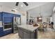 Open kitchen concept with gray island, stainless steel refrigerator, and seating area at 6264 E Omega St, Mesa, AZ 85215