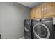 Laundry room with a modern washer and dryer set and overhead storage cabinets at 6264 E Omega St, Mesa, AZ 85215