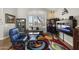 Comfortable living room features a blue armchair, a colorful rug, and large windows with shutter blinds at 6264 E Omega St, Mesa, AZ 85215