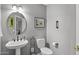 Powder room features a decorative mirror, pedestal sink, and a matching commode at 6264 E Omega St, Mesa, AZ 85215