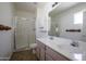 Bathroom featuring a shower with glass doors, double sink vanity, and neutral paint at 6942 S Championship Dr, Chandler, AZ 85249