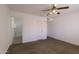 Spacious bedroom featuring neutral paint and carpeted floor with ceiling fan and ensuite bathroom at 6942 S Championship Dr, Chandler, AZ 85249