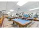 Well-lit billiard room features multiple pool tables with blue felt, pendant lighting and plenty of seating at 6942 S Championship Dr, Chandler, AZ 85249