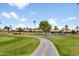 Picturesque golf course featuring a smooth cart path, a serene pond, and lush green landscaping at 6942 S Championship Dr, Chandler, AZ 85249
