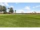 Expansive view of the meticulously maintained golf course with a calm lake and charming residential houses at 6942 S Championship Dr, Chandler, AZ 85249