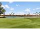 Scenic view of the well-manicured golf course with a tranquil pond and residential homes in the background at 6942 S Championship Dr, Chandler, AZ 85249