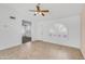Open floor plan with tile flooring, ceiling fan, and arched window with shutters at 6942 S Championship Dr, Chandler, AZ 85249