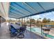 Overhead view of a partially covered patio area with dining tables and a view of the pool and surrounding landscape at 6942 S Championship Dr, Chandler, AZ 85249
