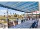 An outdoor patio with dining tables and a view of a lake, landscaping, and a nearby structure at 6942 S Championship Dr, Chandler, AZ 85249