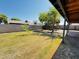 Spacious backyard featuring a large grassy area, play structure, mature tree, and privacy wall at 7141 W Denton Ln, Glendale, AZ 85303