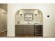 Charming bar area includes a wine refrigerator, stylish lighting, and beautiful backsplash at 8425 E Welsh Trl, Scottsdale, AZ 85258