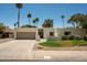 Charming single-story home featuring a well-manicured lawn, complemented by mature palm trees and landscaping at 8425 E Welsh Trl, Scottsdale, AZ 85258