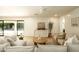 Bright living room with white sofa and chairs, a round coffee table, and access to the backyard pool area at 8425 E Welsh Trl, Scottsdale, AZ 85258