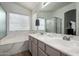 Bright bathroom with double sinks, soaking tub, and a glass-enclosed shower at 1033 E Mountain Vista Dr, Phoenix, AZ 85048