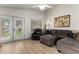 Comfortable living room features French doors, wood flooring, and a cozy sectional sofa at 1033 E Mountain Vista Dr, Phoenix, AZ 85048