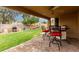 Covered patio with ceiling fan, outdoor seating, and a view of the lush, green backyard at 1033 E Mountain Vista Dr, Phoenix, AZ 85048