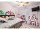 Charming bedroom with pink walls, a bed with cozy linens, ceiling fan and personal decorations at 10407 W Reade Ave, Glendale, AZ 85307
