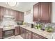 Kitchen features sleek stainless steel appliances, dark wood cabinets, granite countertops, and tile backsplash at 10407 W Reade Ave, Glendale, AZ 85307