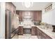 This modern kitchen features stainless steel appliances, granite countertops, dark wood cabinets and a stylish backsplash at 10407 W Reade Ave, Glendale, AZ 85307