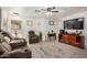 A comfortable living room featuring plush reclining furniture, a ceiling fan, and modern flooring at 10407 W Reade Ave, Glendale, AZ 85307