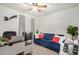 Bright office with a modern ceiling fan, blue sofa, and functional workspace at 10407 W Reade Ave, Glendale, AZ 85307