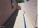 Cement patio area between a wall and building with window and satellite dish at 10407 W Reade Ave, Glendale, AZ 85307