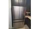 Stainless steel refrigerator with dark brown cabinets and granite countertops in kitchen at 10407 W Reade Ave, Glendale, AZ 85307
