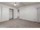 Neutral carpeted bedroom with ceiling fan, closet, and doorway to the bathroom area at 1053 S 96Th St, Mesa, AZ 85208