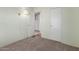 A carpeted bedroom with an interior door, closet, and wall-mounted light fixture at 1053 S 96Th St, Mesa, AZ 85208