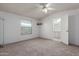 Spacious bedroom with neutral carpet and a ceiling fan, adjacent to the bathroom at 1053 S 96Th St, Mesa, AZ 85208