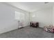 Bright bedroom featuring gray carpet, a window with blinds, and neutral walls at 10986 W Polk St, Avondale, AZ 85323